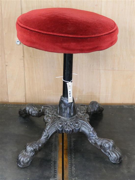 A revolving piano stool with cast iron base Width of base 37cm
